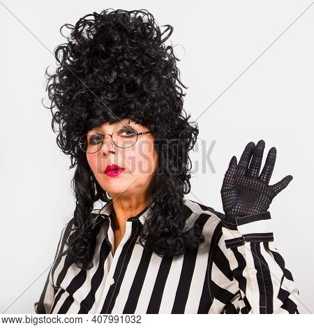 Elegant Woman In Black Baroque Wig, Black-white Striped Clothes And Eyeglasses, Waves His Hand In A 
