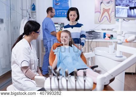 Little Girl Looking Happy At Dentist After Professional Tooth Cavity Treatment In Dental Office. Chi