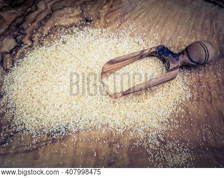 Dried Garlic Granules On Brown Olive Wood
