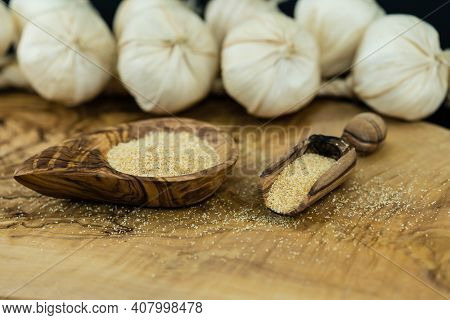 Dried Garlic Granules On Brown Olive Wood