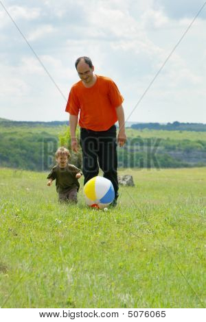 Otec a syn hraje s míčem venku