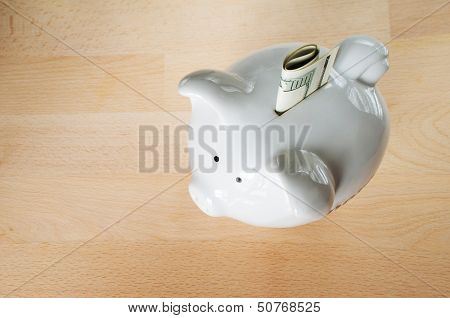 Us $100 Dollar Bill, Folded, Sticking Out Of Small White Piggy Bank