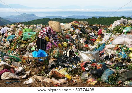 People pick up refuse at rubbish dump