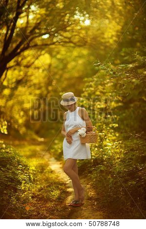 Beautiful Young Woman In Dress In Garden On Sunset