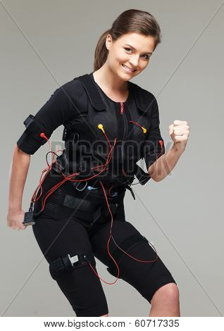 Young woman doing exercise  in Electro Muscular Stimulation EMS training costume 