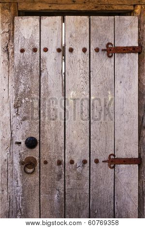old wooden door with rusty hinges metal rivets