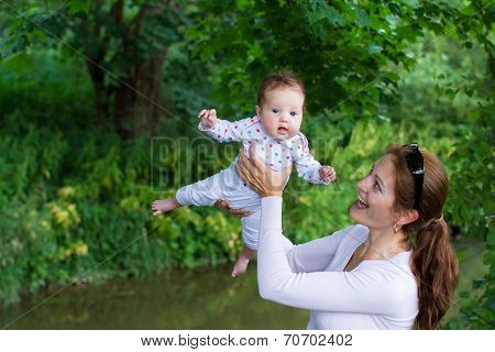 Young Mother Playing With Her Adorable Baby In A Park