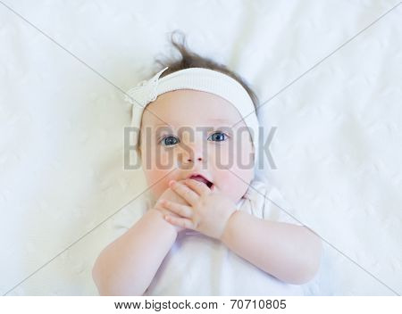 Cute Baby Girl In White Shirt On White Blanket With White Bow