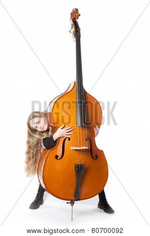 Young Blond Girl Looks From Behind Double Bass In Studio