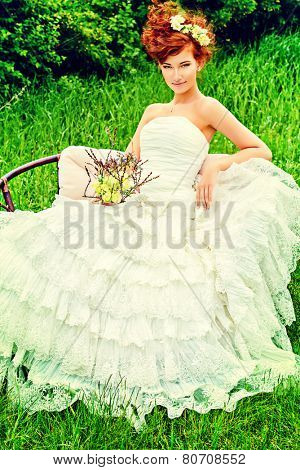 Beautiful smiling bride with chaming red hair. Wedding dress and accessories. Wedding decoration. 
