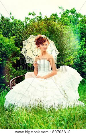 Beautiful smiling bride with chaming red hair. Wedding dress and accessories. Wedding decoration. 