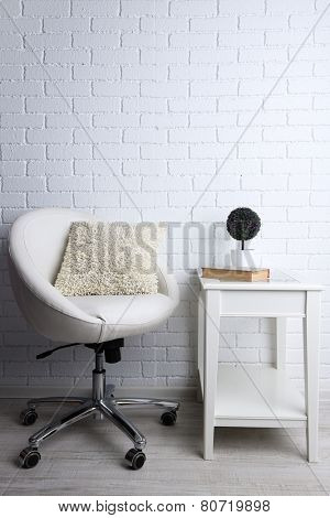 Modern interior with chair and pillow on it on white brick wall background