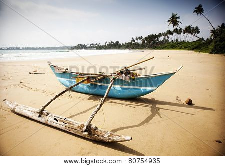 Untouched tropical beach with palms and fishing boats in Sri-Lanka