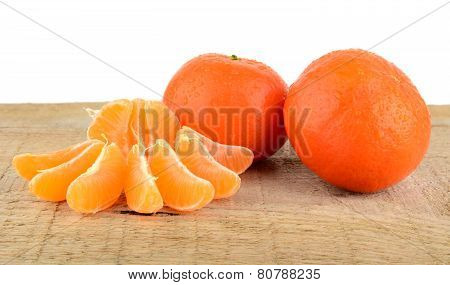 Mandarines With Pieces Isolated On Wooden Table