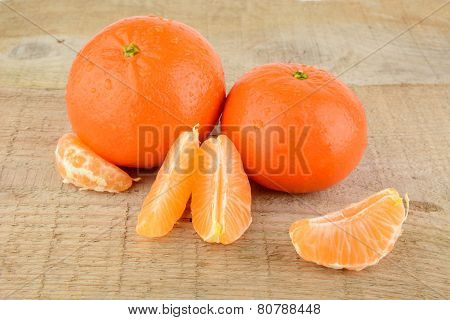 Mandarines With Pieces Isolated On Wooden Table