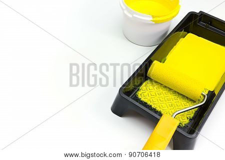 Paint Roller In Tray With Yellow Paint Bucket