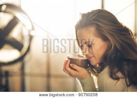Closeup Of Smiling Brunette Holding And Smelling Hot Coffee