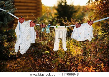 Baby's Clothes Are Hanging And Dryingon A Clothesline Outdoor In