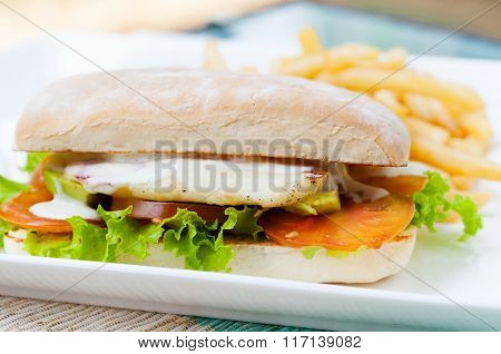 Vegetarian Ciabatta with tomatoes, grilled cheese haloumi, avocado and lettuce with french fries on