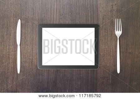 Gadget Concept With Blank Digital Tablet Screen With Fork And Knife On Brown Wooden Table, Mock Up