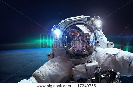 International Space Station with astronaut over the planet Earth. Elements of this image furnished b