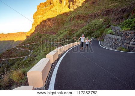 Carefree couple running on the mountain roadside