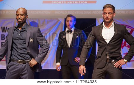 Male Physique Models Show Their Best In Suit On Stage