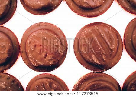 Rows of many chocolate biscuit cookies close up background