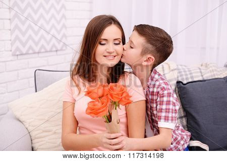 Son celebrating his mother with flowers