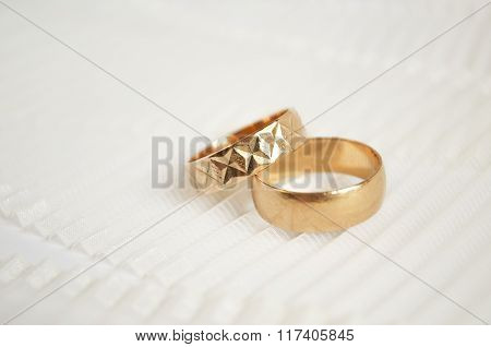 Two Golden Wedding Rings On Light Ribbon Background