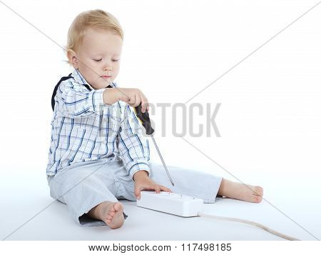 boy plays with plug and screwdriver