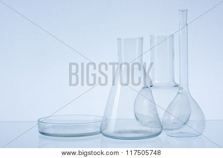 Assorted empty laboratory glassware, test-tubes. Blue tone medical background. Copy space for text.