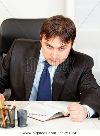 Angry modern businessman banging fist on table