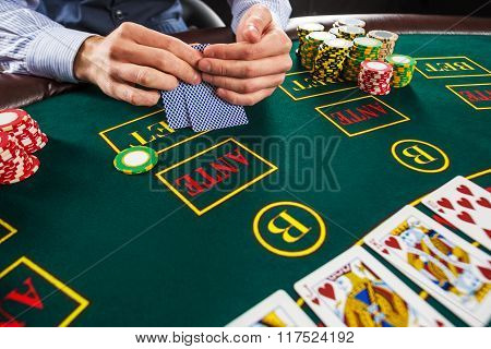 Closeup of poker player with playing cards and chips