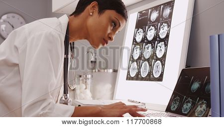 Young Female Medical Assistant Looking At X-ray Scans