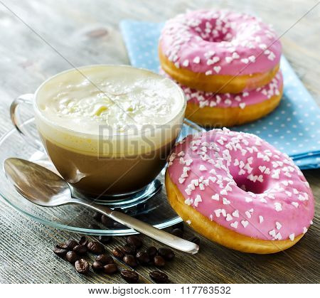 Cup Of Coffee With Pink Glazed Donuts On Wooden Background