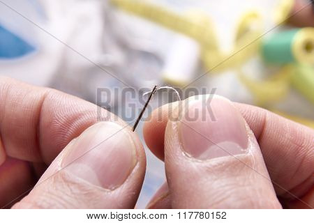 Fingers Of A Tailor Threading A Needle