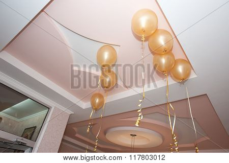 Golden yellow balloons hanging from the ceiling.
