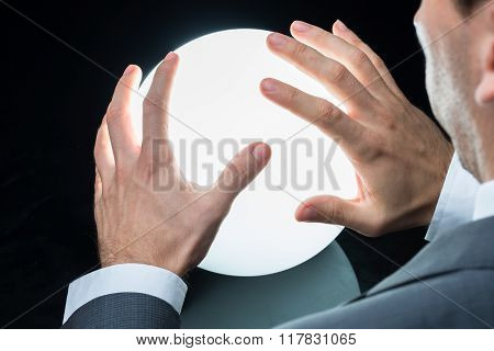 Businessman Predicting Future On Crystal Ball