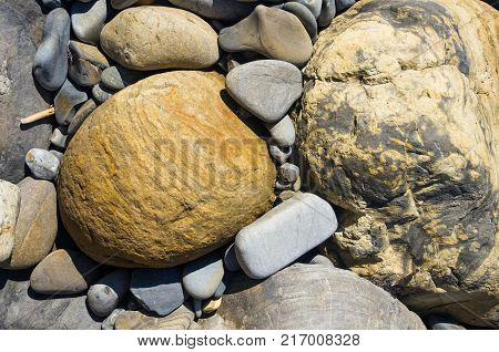 boulders and colorful pebbles on the beach on a warm summer day