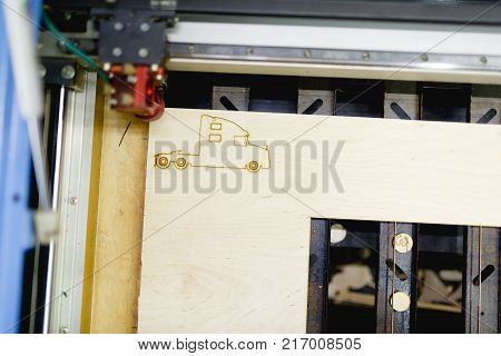 Automatic machine laser-burning a truck without a trailer on the workpiece. Top view at an angle close up