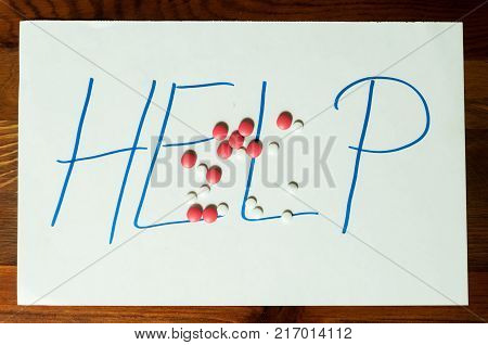 Help sign letters written on paper with strong pain killer pills or tablets addiction or suicidal concept