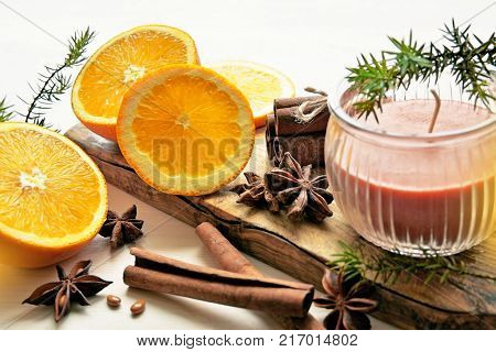 fresh oranges with anisestars, cinnamon sticks, juniper branches and aroma candle, Christmas time composition