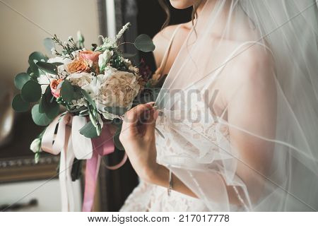 Bride holding big and beautiful wedding bouquet with flowers.