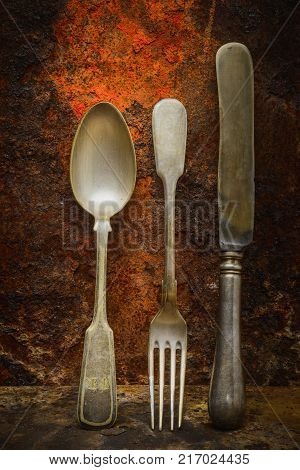 Still life- vintage forks. Rusty metal abstract background