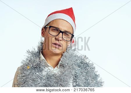 man in glasses and with tinsel on his neck, portrait, christmas.