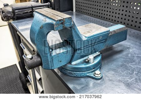 Metal vise mounted on a bench table