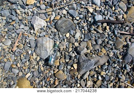 glass bottle washed up by the sea on a pebble beach