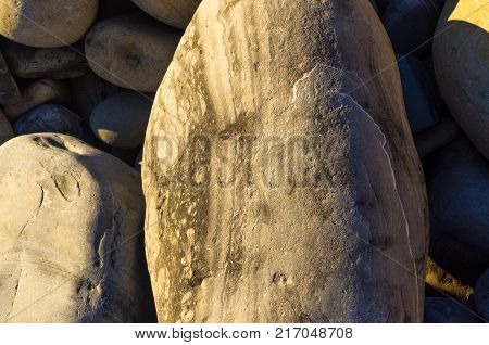 boulders and colorful pebbles on the beach on a warm summer day
