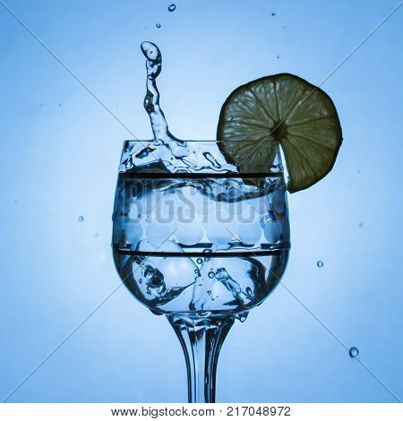 glorious splash in a crystal glass on the edge of which a lemon